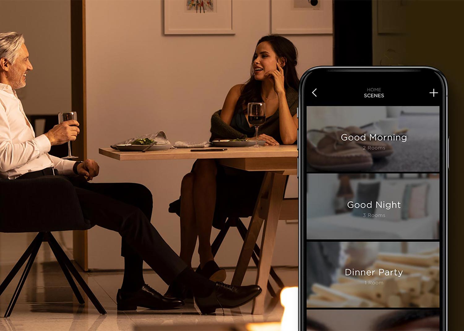 Couple having dinner with Savant app showing lighting scene options on phone screen
